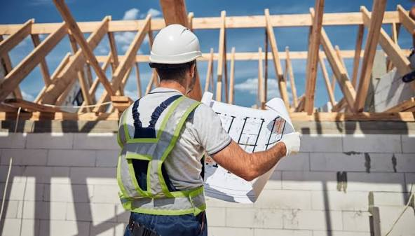 Builder reviewing plans on a construction site