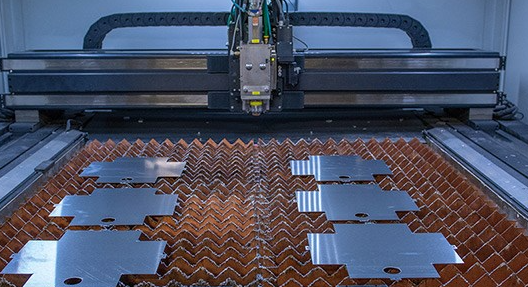 Laser cut stainless steel parts nested on the cutting bed at Pressform